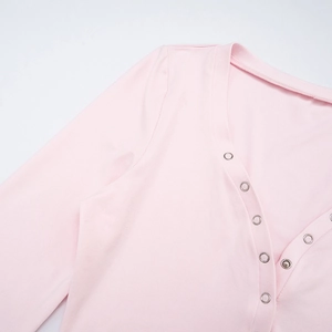Detail of light pink long sleeve top showing silver snap buttons and knit texture