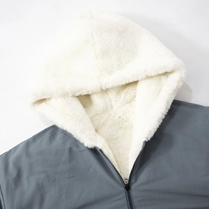 Detail of dark grey hooded jacket featuring thick white faux shearling lining and metal zipper