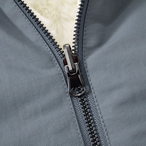 Detail shot of blue windproof fabric with plush white Sherpa lining and metal zipper