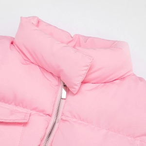 Detail of pink puffer vest showing stand collar and smooth metal zipper texture