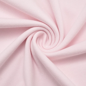 Close-up of soft pink knitted cotton fabric showing detailed texture and smooth draping