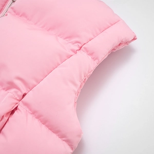 Detailed macro view of pink quilted fabric with metal zipper on padded vest top