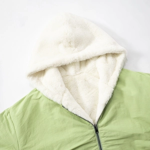 Detailed close-up of light green hooded jacket with soft white sherpa fleece lining inside