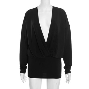 Detail of black long sleeve deep V-neck dress featuring crossed wrap design and knit fabric
