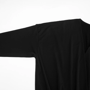 Detail view of smooth black fabric with precise stitching on the sleeve and shoulder