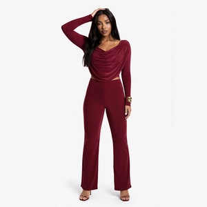 Detail of burgundy two-piece set featuring draped long sleeve top and flared high waist pants