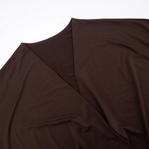 Detail of deep brown knit fabric showing V-neckline stitching and smooth texture