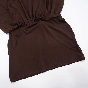 Detailed macro view of ruched elastic waist and soft knit fabric on deep brown dress