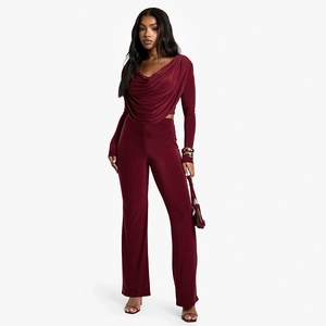Detail of burgundy two-piece set featuring draped neckline top and high-waisted wide trousers