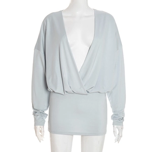 Detail view of light blue knitted dress featuring deep V-neck and draped pleats