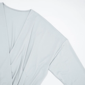 Detail view of the deep V-neck and silky smooth fabric texture of the light blue dress