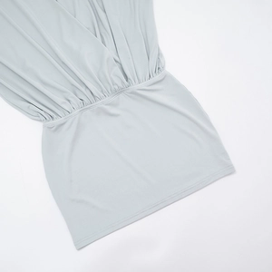 Close-up of sage green mini dress featuring elastic waist and gathered pleated details