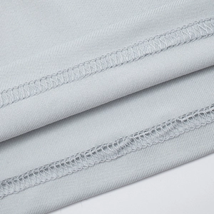 Detail of light grey knit fabric featuring high-density overlock stitching and smooth texture