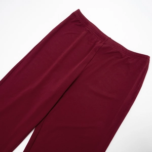 Detailed close-up of wine red elastic high waist and smooth fabric of casual pants