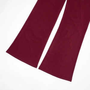 Detail shot of burgundy flared trousers made from premium draped elastic knit fabric