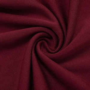Macro shot of premium burgundy ribbed knit fabric showing fine texture and elasticity