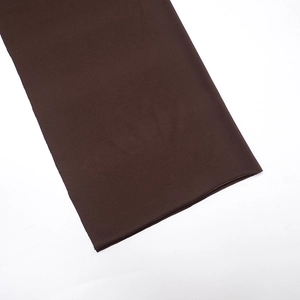 Gros plan sur la texture du tissu marron foncé et les coutures plates de la combinaison
