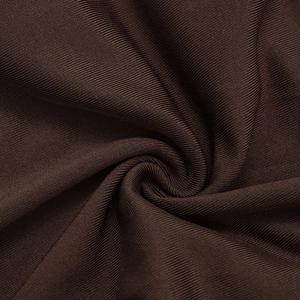 Gros plan du tissu en maille côtelée marron foncé montrant les textures et le drapé doux