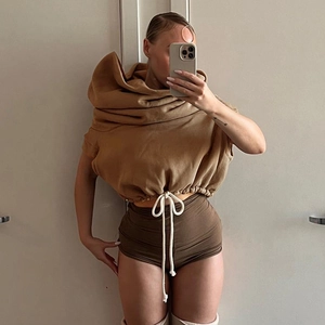 Detail of tan cropped hoodie featuring wide neckline and thick white cotton drawstring