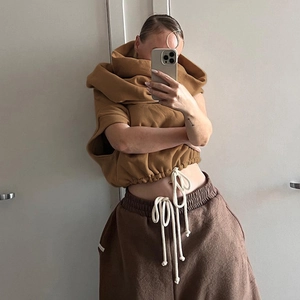 Detail of camel sleeveless drawstring hoodie and dark brown high waist joggers