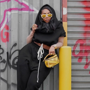 Detail of black hooded sweatshirt with bold white drawstrings and high waist joggers