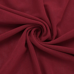 Detail shot of breathable red mesh fabric with fine honeycomb texture and soft drape