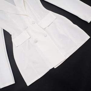 Detail of white double-breasted dress showing lapel collar and flap pocket details