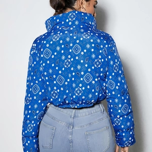 Rear view detail of women's reversible quilted jacket with white paisley pattern on dark blue