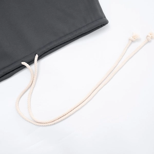 Detailed macro view of cream woven drawstring on dark grey hooded sweatshirt fabric