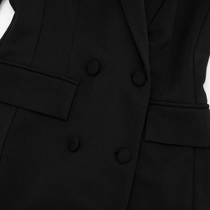 Detail of slim-fit blazer dress featuring double-breasted buttons and flap pocket design