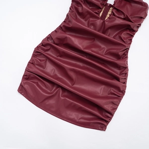Détail d'une robe courte bordeaux en similicuir avec texture froncée et fermeture éclair