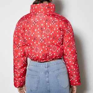 Detail of red bandana paisley pattern and quilted texture on the women's puffer jacket