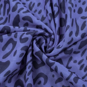 Close-up of semi-transparent dark purple mesh fabric featuring black leopard animal prints