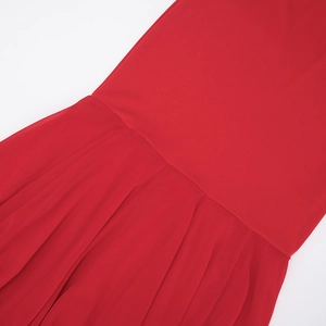 Macro detail of red chiffon dress featuring neat horizontal seams and vertical pleats