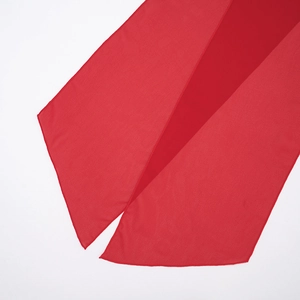 Detail of red chiffon streamer with light texture and elegant draped edge of the maxi dress
