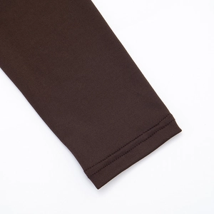 Detail of double-needle stitched cuff on a brown long-sleeve dress with pleated fabric