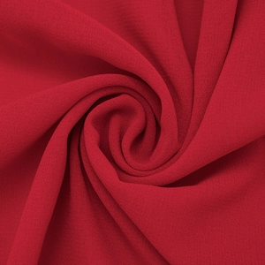 Macro shot of dark red chiffon fabric with a matte texture and elegant draped layers