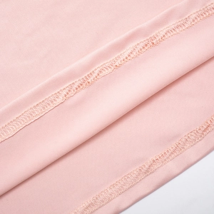 Close-up of pink knit fabric featuring precise double-stitched seams and clean edge finishing