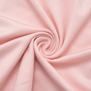 Macro detail of elegant pink pleated knit fabric showing fine vertical ribbed texture