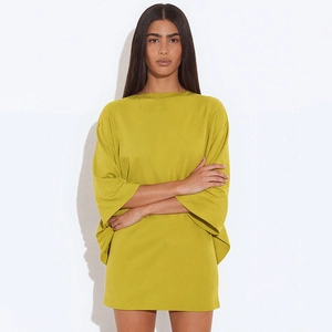 Détail d'une robe oversize vert moutarde avec encolure bateau et manches chauve-souris