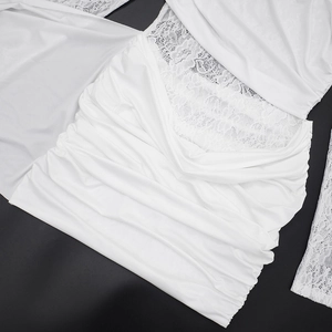 Detail des weißen Kleides mit elegantem Spitzen-Patchwork und gerafftem Strukturstoff