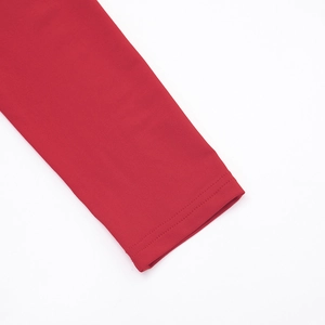 Gros plan d'une manche de robe en tricot rouge montrant des finitions de couture doubles