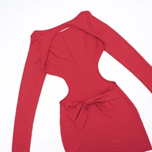 Détail d'une robe rouge ajustée à manches longues avec dos nu et nœud décoratif en 3D