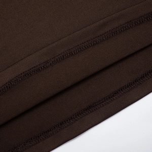 Détail de couture surjeteuse professionnelle sur l'ourlet en tricot marron foncé