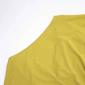 Détail d'une robe courte jaune élégante montrant la texture du tissu et le col bénitier