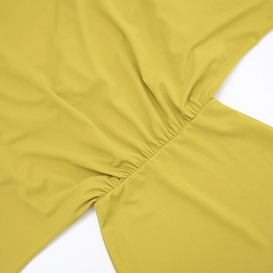 Détail du tissu jaune moutarde avec coutures plissées et finitions soignées