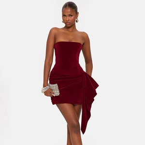 Détail de la mini robe bustier en velours bordeaux avec design drapé plissé