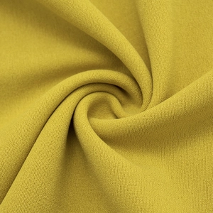 Vue détaillée du tissu en maille jaune moutarde avec un tissage texturé premium
