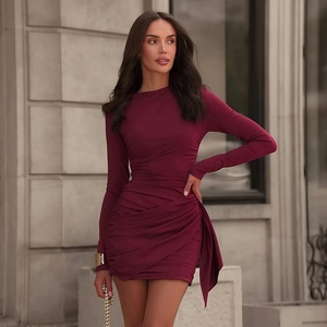 Detail of burgundy ruched mini dress with long sleeves and elegant side drape streamers