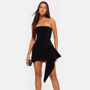 Détail d'une élégante mini robe bustier en velours noir avec drapé latéral et volants